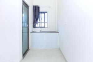 a white kitchen with a sink and a window at OYO 1064 Phat Tai Hotel And Apartment in Da Nang