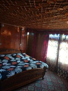 a bedroom with a bed and two windows at Pasadona Floating Houseboat in Srinagar