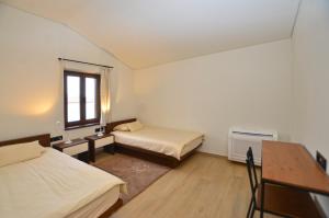 a room with two beds and a desk and a window at Casa Farfalla in Bale +27 photos