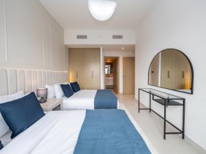 een hotelkamer met 2 bedden en een spiegel bij Luxurious 2BR Apt in Downtown Pool and Gym Access in Dubai