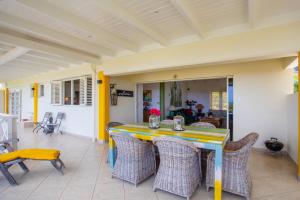 a dining table and chairs on a patio at Villa Dol fijn huis in Willemstad