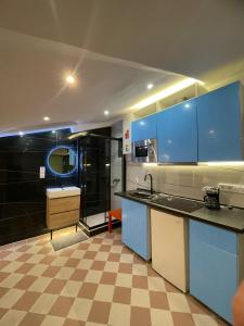 a kitchen with blue cabinets and a tile floor at SmartApart, Plaza Mayor, Madrid Center in Madrid