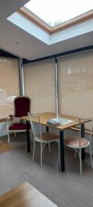 ユリューニュにあるLa Casita de Rose au calme proche plage d'Hendaye - 26 m2 Bien équipé Parking privé Jardinのテーブルと椅子と窓のある部屋 +21枚の写真
