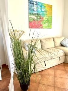 uma sala de estar com um sofá e um vaso de plantas em Casa Sunshine 2.0 - Vacanze al mare em Punta Braccetto