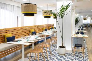 a dining room with long tables and chairs at HD Parque Cristobal Tenerife in Playa de las Americas