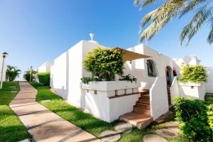 a white house with stairs and a palm tree at HD Parque Cristobal Tenerife in Playa de las Americas
