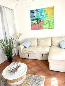 uma sala de estar com um sofá e uma mesa em Casa Sunshine 2.0 - Vacanze al mare em Punta Braccetto