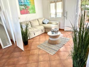 sala de estar con sofá y algunas plantas en Casa Sunshine 2.0 - Vacanze al mare en Punta Braccetto