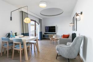a dining room and living room with a table and chairs at HD Parque Cristobal Tenerife in Playa de las Americas
