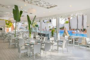 a restaurant with tables and chairs and a pool at HD Parque Cristobal Tenerife in Playa de las Americas