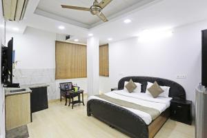 ein Schlafzimmer mit einem Bett, einem Tisch und einem Stuhl in der Unterkunft OYO 78876 The Premium Villa in Neu-Delhi