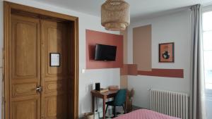 a bedroom with a door and a desk with a chair at Au Coeur des Eléments in Saint-Nicolas-de-la-Grave
