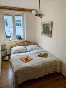 Un dormitorio con una cama con dos sombreros. en Apartmán POD LAMPOU, en Žďár nad Sázavou