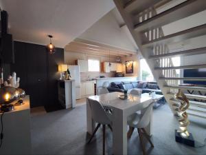 soggiorno e cucina con tavolo e sedie bianchi di LE DUPLEX DU MARCHÉ a Châteauroux