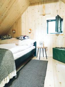 a bedroom with two beds in a wooden wall at Slow Huts in Miedzygorze