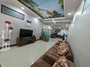 ein Wohnzimmer mit einem Sofa und einem Flachbild-TV in der Unterkunft RT Mutbu&Tukthuan in Aizawl