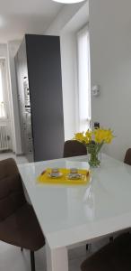 a white table with a vase of yellow flowers on it at RIO HOME - Como in Como