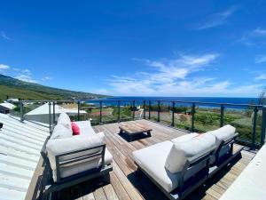 a deck with two couches and a view of the ocean at Duplex Ti Rooftop spa et vue mer in Saint-Leu