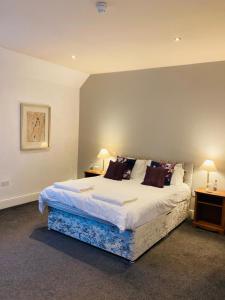 una camera da letto con un grande letto con due tavoli e due lampade di The Coach and Horses a Winchester