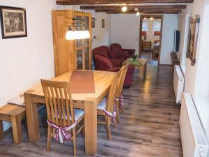 una sala da pranzo e un soggiorno con tavolo e sedie di Ferienhof Verse Ferienwohnung Waldblick a Lennestadt Altre 10 foto