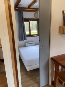 ein kleines Schlafzimmer mit einem Bett und einem Fenster in der Unterkunft L'imprévu in Vaulnaveys-le-Bas