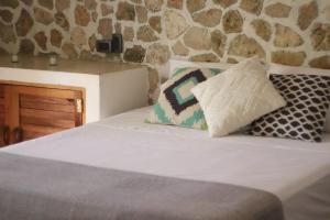 a bed with two pillows on top of it at Casa Ixtzá in Nimá