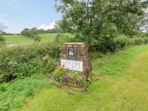 a sign for aeryery in a field with flowers at Orton Cottage in Appleby +1 photo
