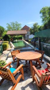 - une table de pique-nique en bois, des chaises et une piscine dans l'établissement Détendez-vous à Montverdun, à Montverdun