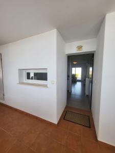 an empty hallway with a white wall and a window at Golf Las Terrazas de La Torre LRVDM House in Roldán