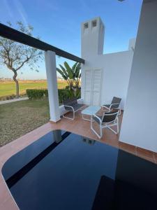 a house with two chairs and a swimming pool at Golf Las Terrazas de La Torre LRVDM House in Roldán