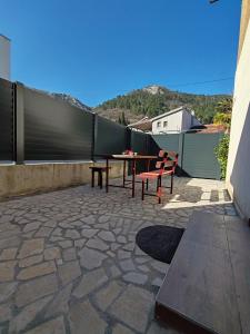 a patio with a table and benches and a fence at Apartment Libar with Terrace and private Parking in Mostar