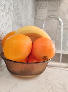 a bowl of oranges and a banana on a counter at Apartment Libar with Terrace and private Parking in Mostar