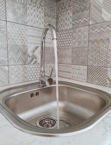 a kitchen sink with water running from a faucet at Apartment Libar with Terrace and private Parking in Mostar