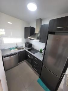 a kitchen with black cabinets and a stainless steel refrigerator at Golf Las Terrazas de La Torre LRVDM House in Roldán