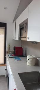 cocina con encimera y microondas en LA CASA logement indépendant 26m2 Calme Proche de tout WIFI fibre Parking privé Jardin terrasse, en Urrugne