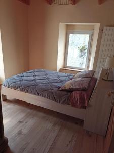 een bed in een slaapkamer met een raam bij Mas de la fontaine in Lafarre