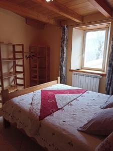 een slaapkamer met een bed met een rode en witte quilt bij Mas de la fontaine in Lafarre