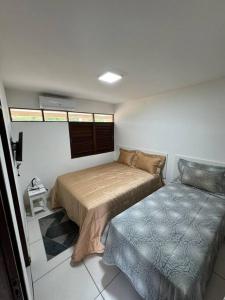 Casa aconchegante em Guadalupe/PE في Sirinhaém: غرفة نوم فيها سرير واريكة