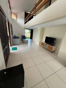 a living room with a tv and a tiled floor at Casa aconchegante em Guadalupe/PE in Sirinhaém