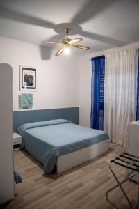 1 dormitorio con 1 cama y ventilador de techo en Albergo La Marinella, en Varazze