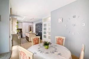 a dining room with a table and chairs and a clock on the wall at Duplex Pozo Canary in Pozo Izquierdo