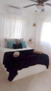 sypialnia z dużym łóżkiem z czarnym kocem w obiekcie Xarraca w mieście Bayahibe