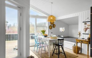 a kitchen and dining room with a table and chairs at 2 Bedroom Stunning Home In Rudkbing in Spodsbjerg