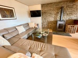 ein Wohnzimmer mit Sofa und Kamin in der Unterkunft Revival Ranch Ferienwohnung in Büllingen