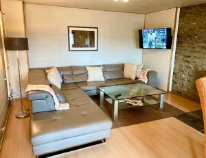 ein Wohnzimmer mit Sofa und Tisch in der Unterkunft Revival Ranch Ferienwohnung in Büllingen