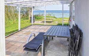 einen Picknicktisch und Stühle auf einer Terrasse mit Meerblick in der Unterkunft Beautiful Home In Nordborg With Kitchen in Torp