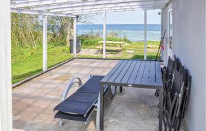 stół piknikowy i krzesła na patio z widokiem na ocean w obiekcie Awesome Home In Nordborg With 2 Bedrooms And Wifi w mieście Torp