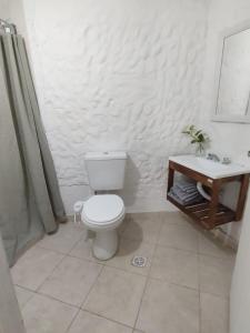 a white bathroom with a toilet and a sink at Departamento Temporario Bianchi in Santiago del Estero