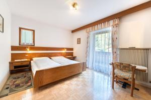 sypialnia z łóżkiem, biurkiem i oknem w obiekcie Zilli Rooms w mieście Lajen