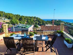 a patio with a table and chairs and the ocean at Casa Marvista - piscina, barbacoa y vistas al mar in Pineda de Mar